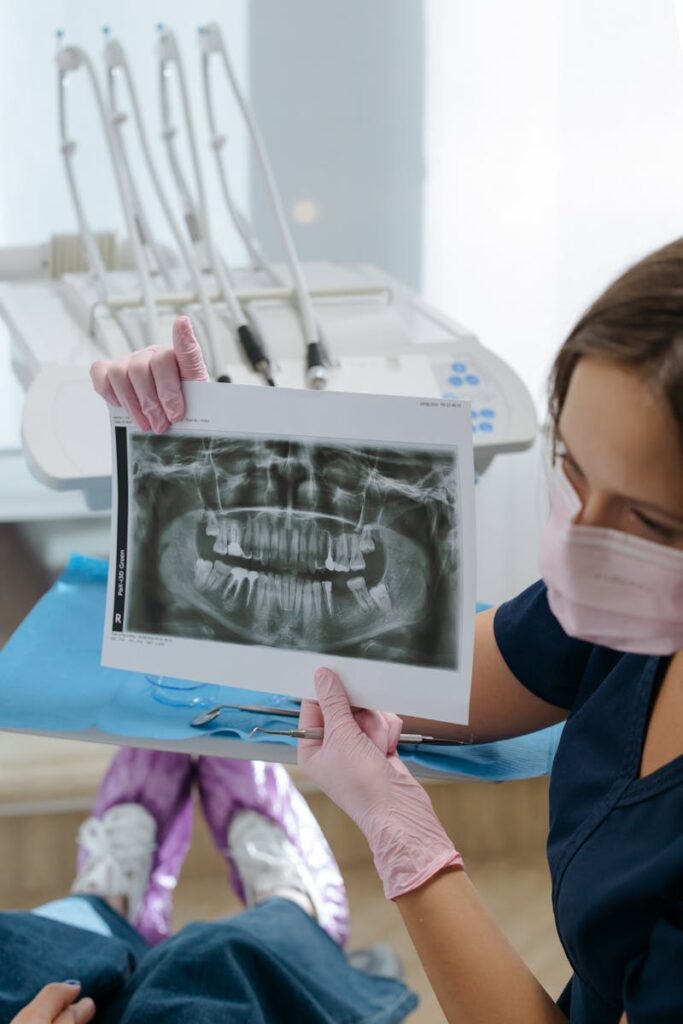 Leading Dental Technology Dentist showing dental x-ray during consultation in a modern clinic setting.